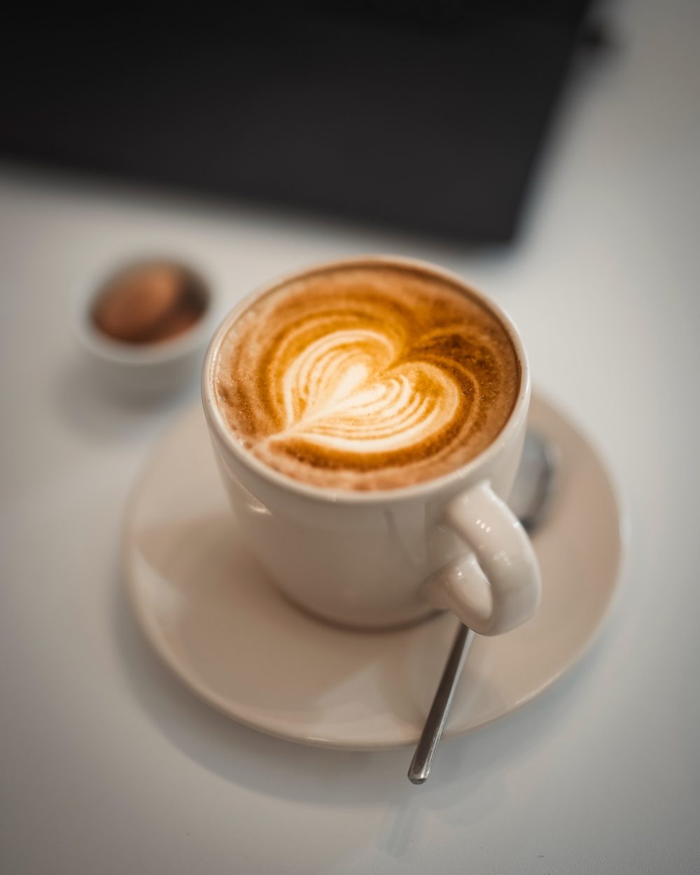 Latte con arte de corazón en taza blanca